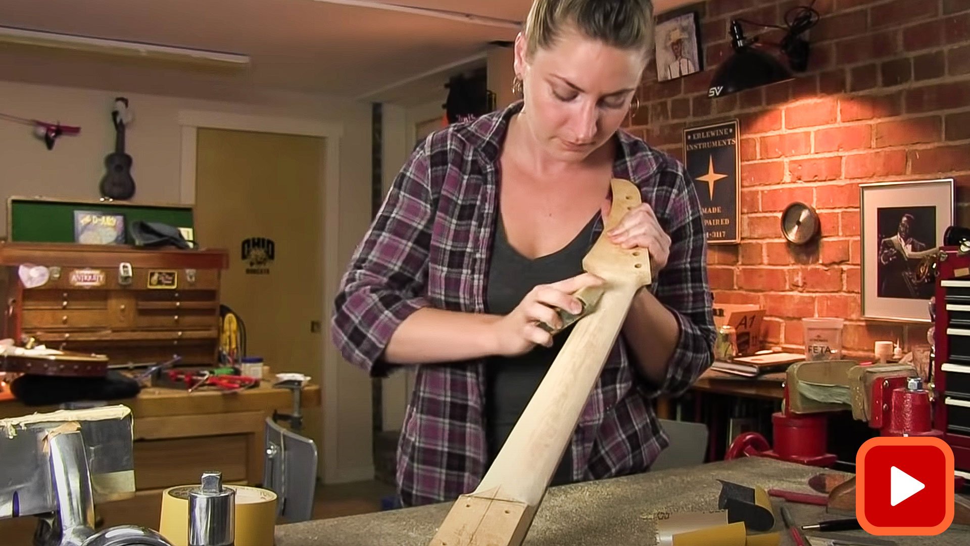 Woman shaping the back of a guitar neck with sandpaper