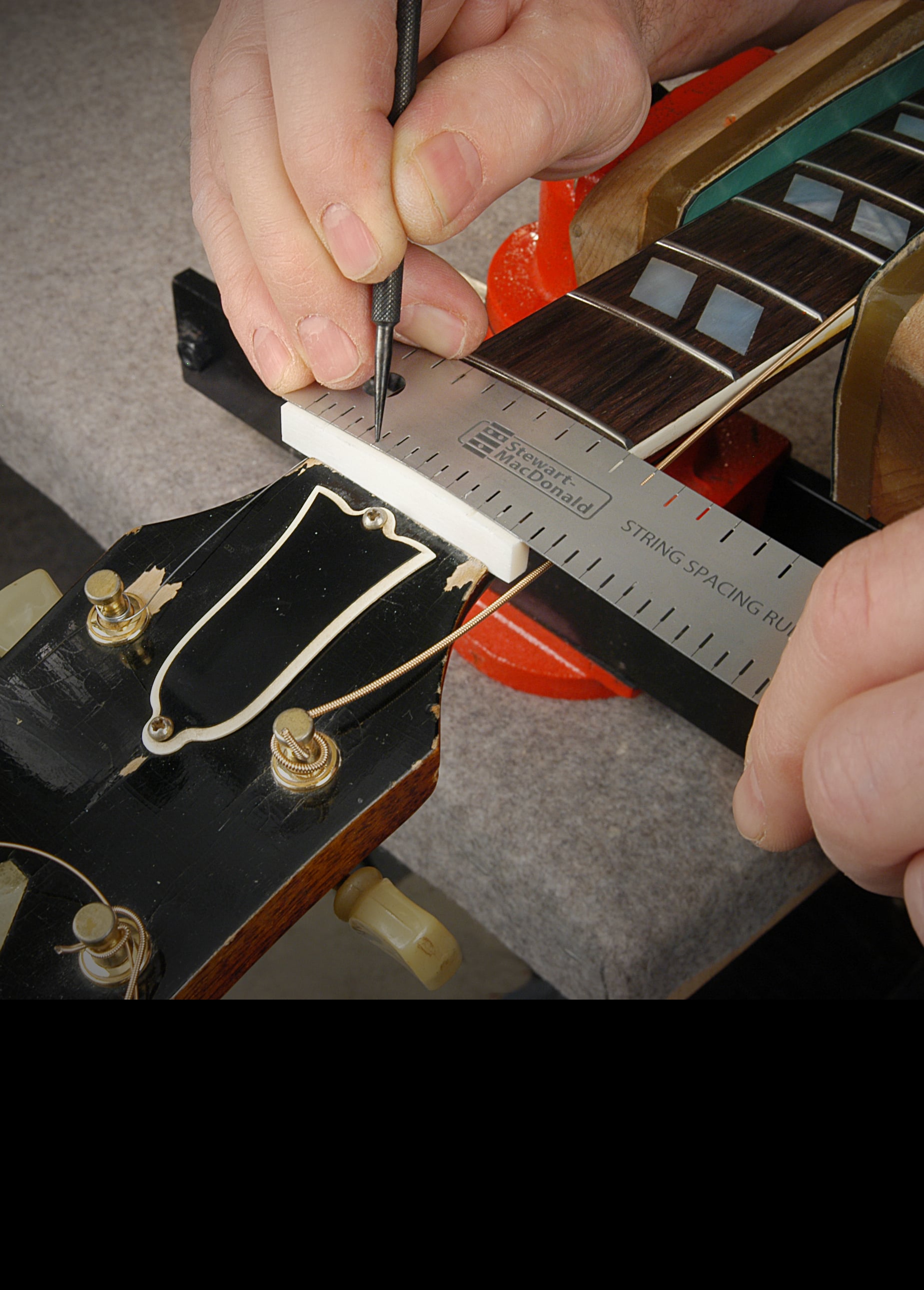 Measuring the slots for a new guitar nut with the String Spacing Rule.
