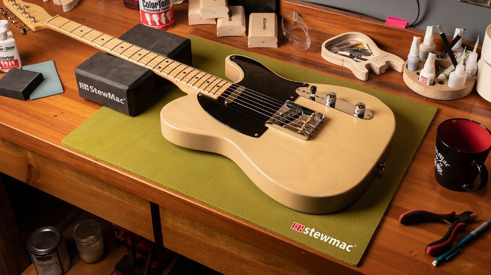 Luthier workbench with Fender Telecaster guitar surrounded by StewMac tools.