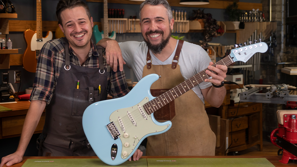 Guys from Driftwood Guitars holding the sonic blue guitar they finished
