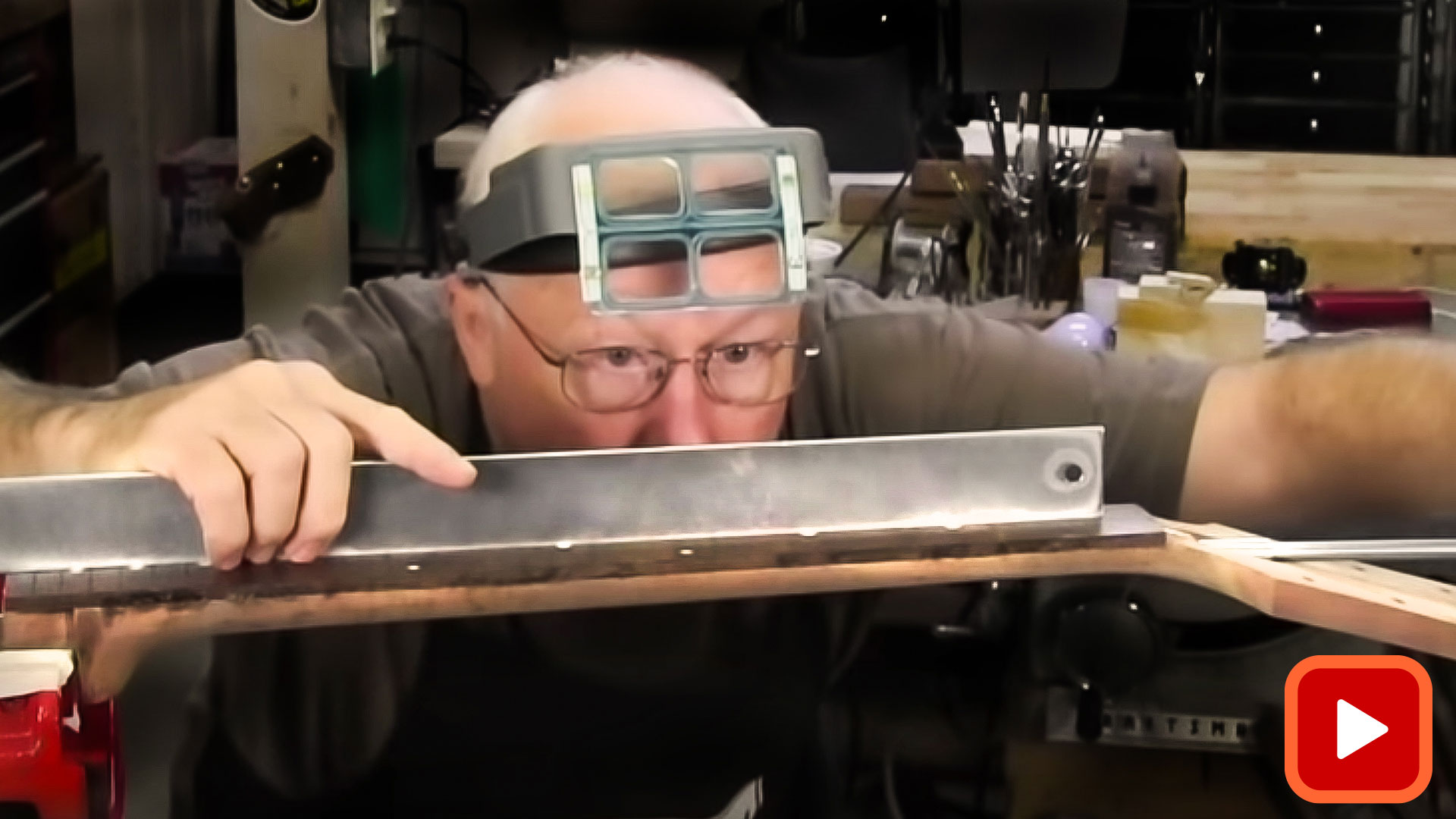Man adjusting truss rod with straight edge