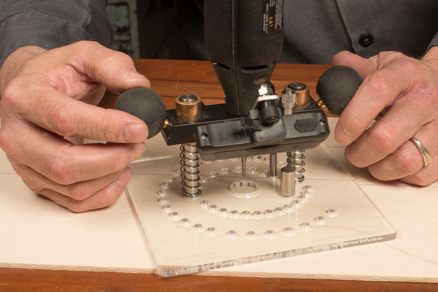 Hands on rosette router base on soundboard