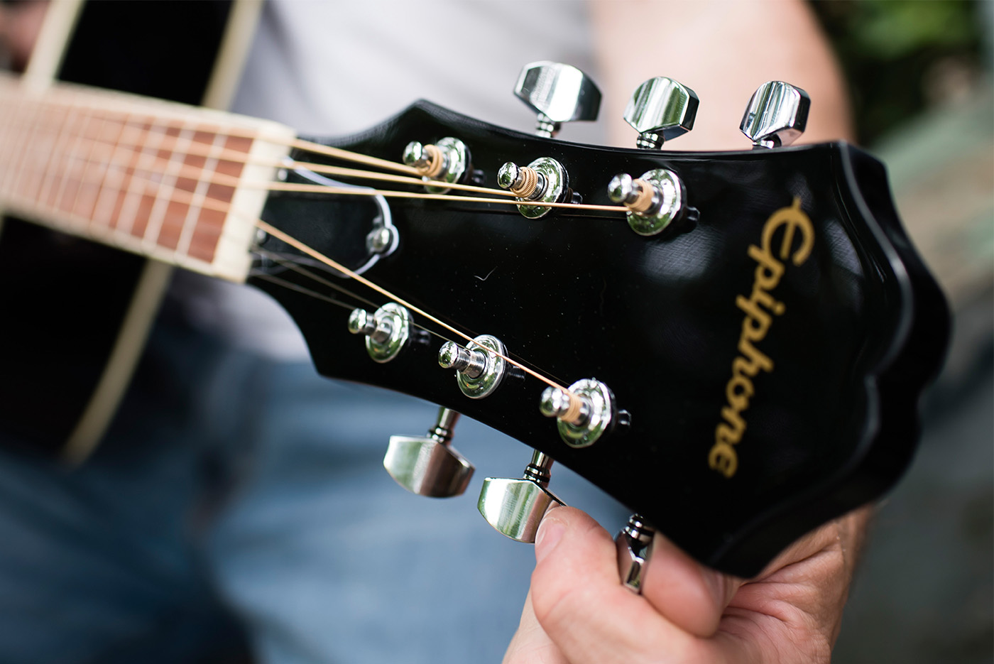 Hands tuning guitar at headstock