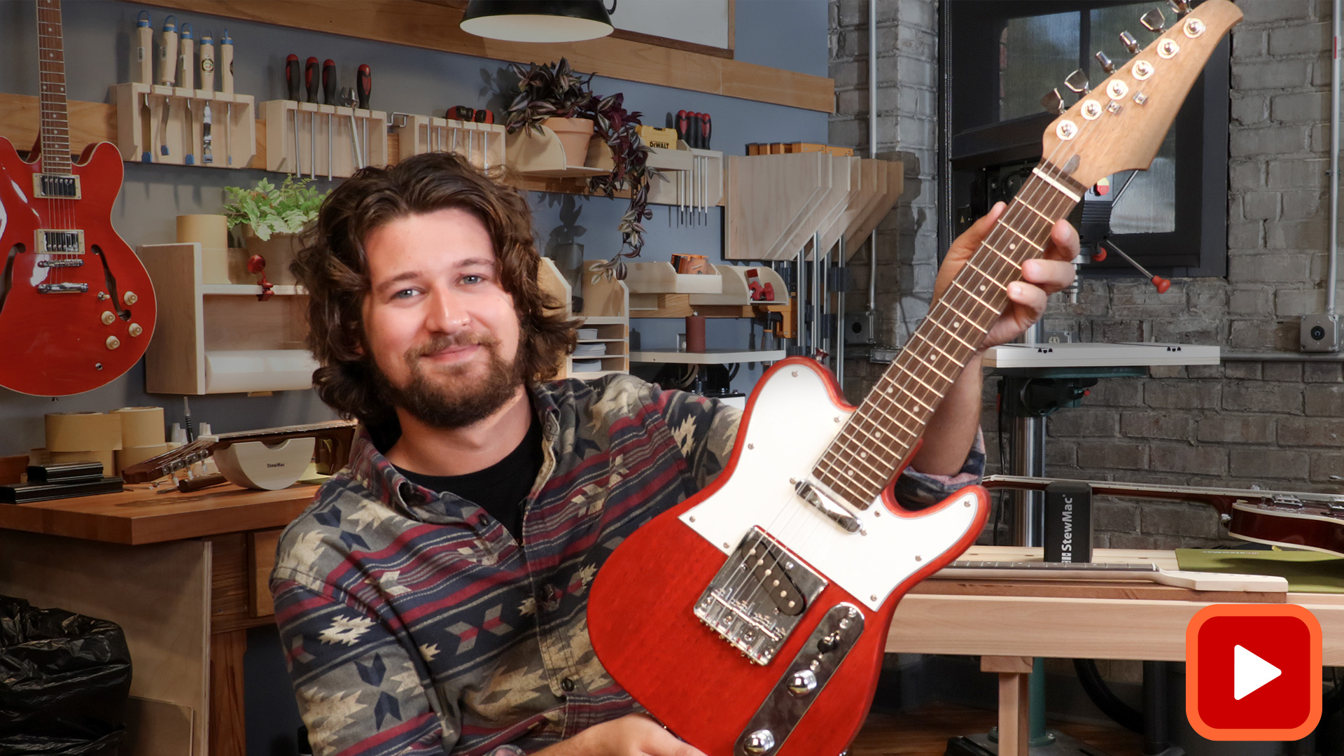 Man holding finished mini guitar