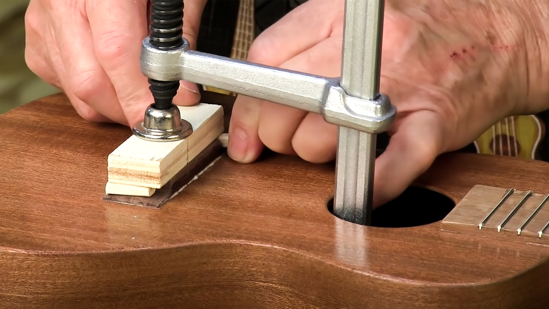 Clamping ukulele bridge through soundhole