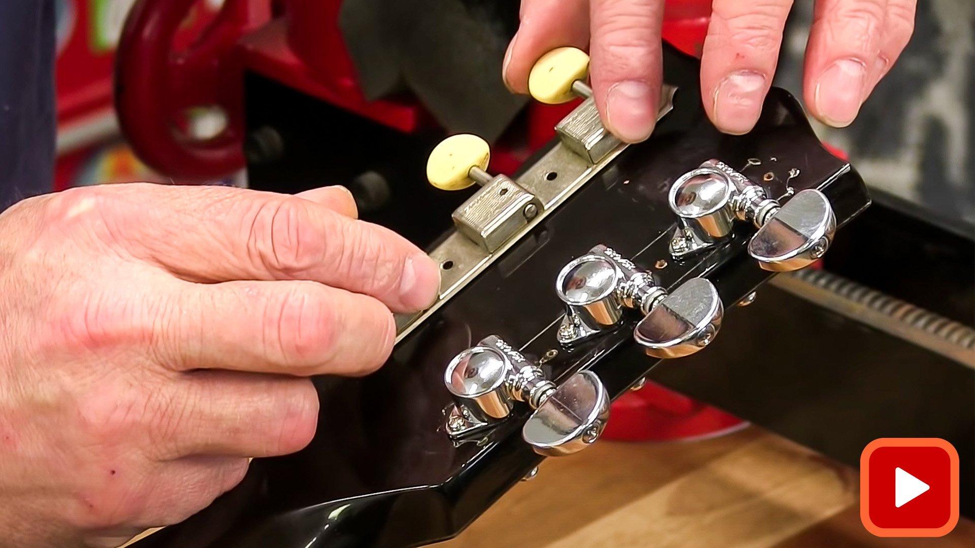 Hands replacing tuners at back of headstock